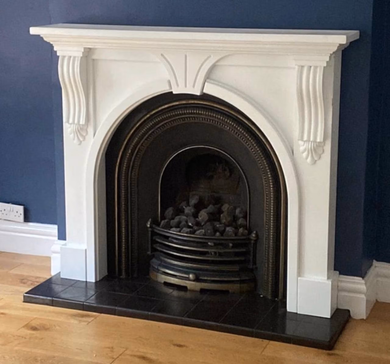 The old fireplace in Appleton before the new installation, a white surround with a cast iron arched insert