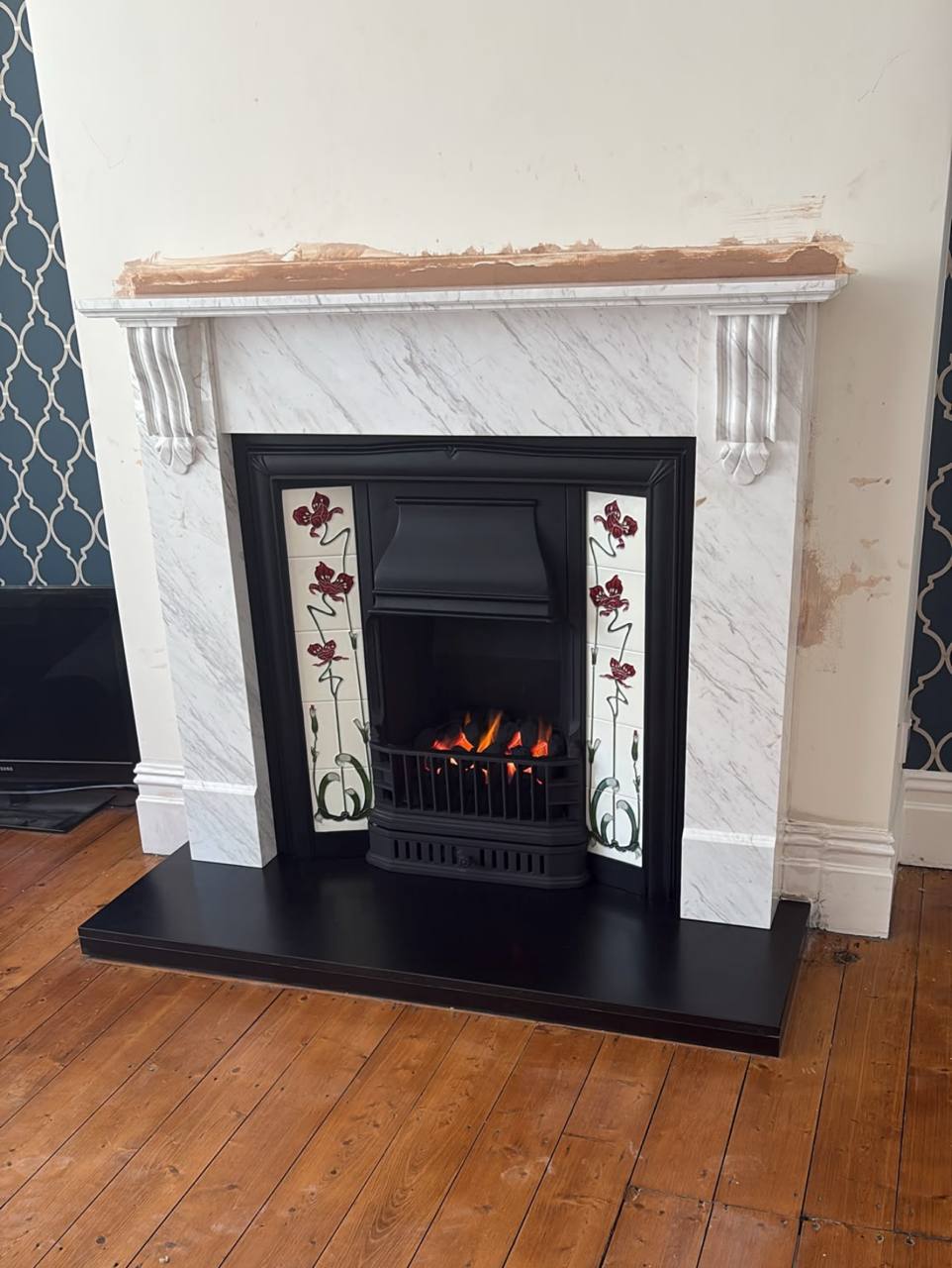 Side view of Carrara marble fireplace and honed black granite hearth, Grappenhall