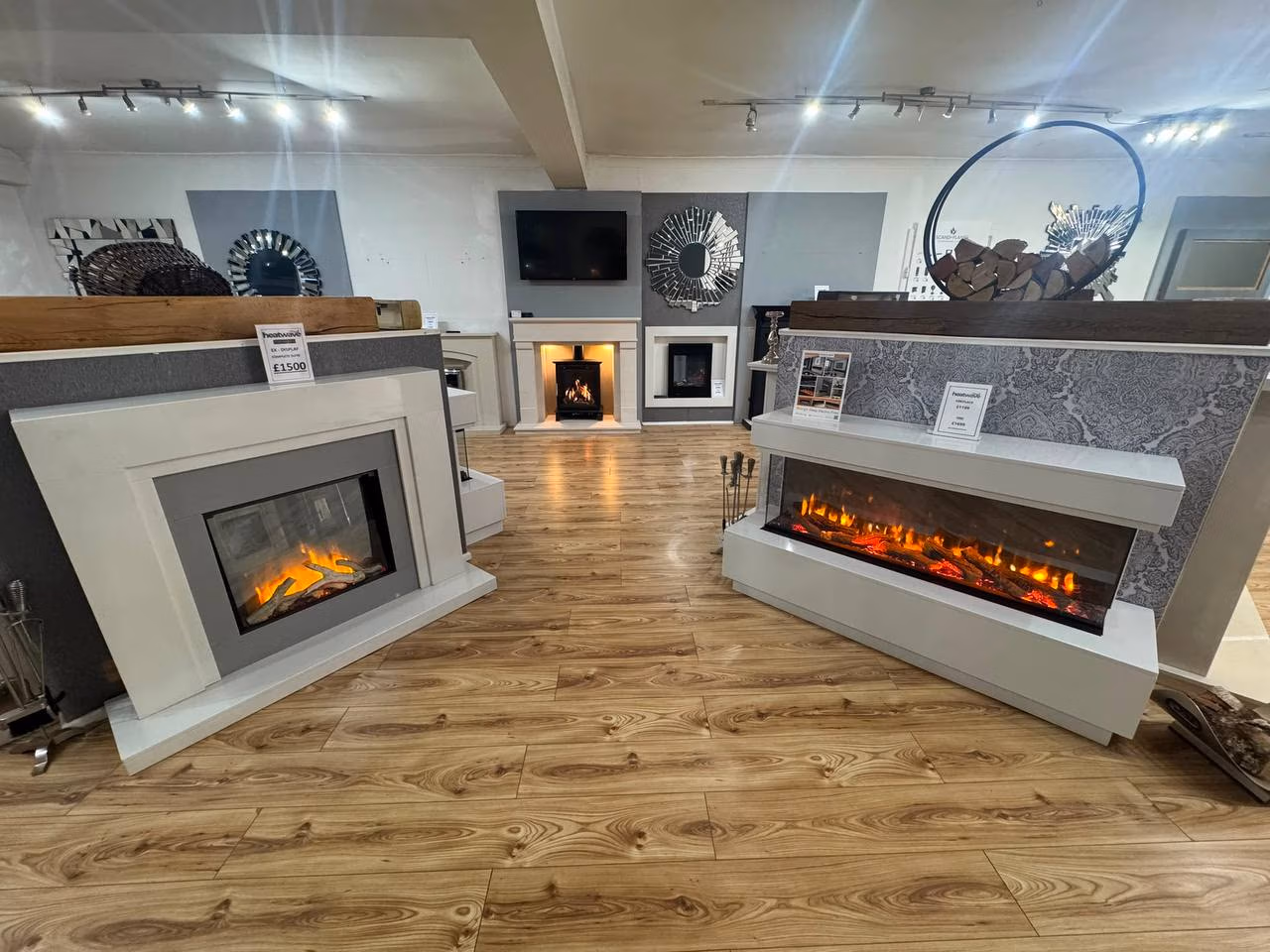 Indoor fireplace showroom with modern electric fires and wood floor